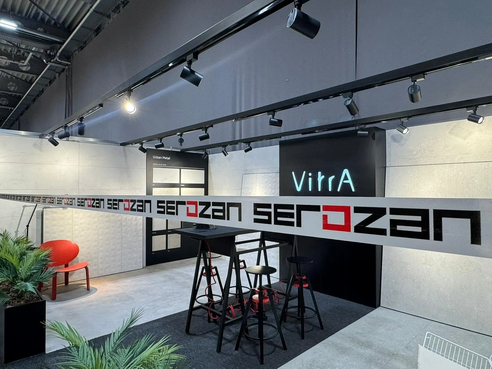 Serozan showroom iç mekan uygulaması; ray spotlu, markalı duvar ve oturma alanı